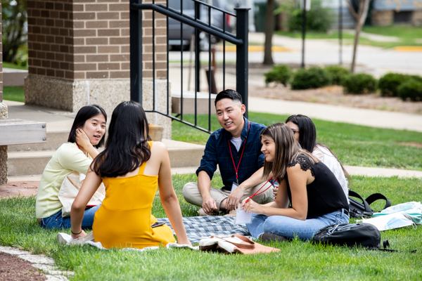 students sitting outside on the grass